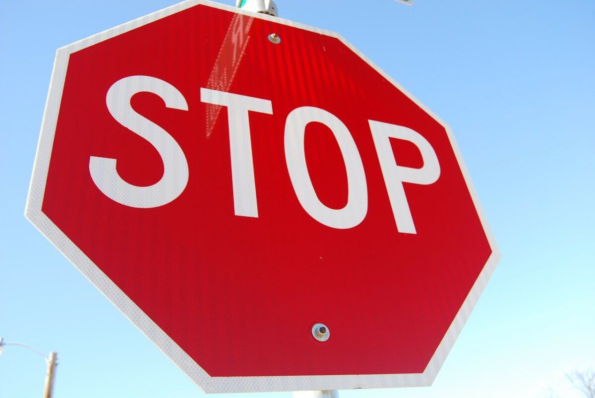 Stop sign image. White text on red octagon reads: STOP