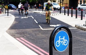 Cycle lane sign with cyclists in the background image