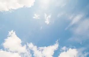 Clouds in a blue sky with sun rayimage