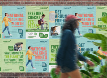 Person waking past posters promoting travel to Park Life - Thorpe Park Leeds