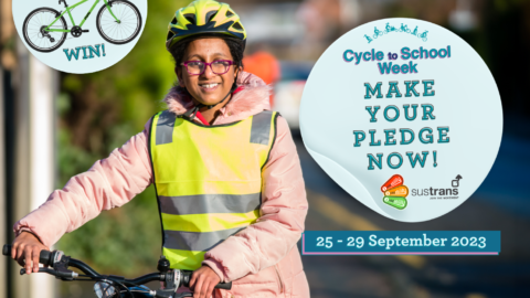 Graphic for Cycle to School Week 25 – 29 September 2023. A high-school aged girl is captured from the waist up, walking with her bicycle on the way to school. She is wearing a high-vis vest and a safety helmet. She is smiling excitedly. Text on a blue circle reads: “Make your pledge now!” above Bikeability & Sustrans logos. Another blue circle shows a prize Frog bicycle with the text “WIN!” with the Frog Bikes logo.