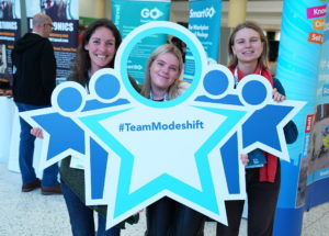 Convention delegates poses with Modeshift STars bopard - Stars shaped people with circle cut out to look through. Text reads; '#TeamModeshift'