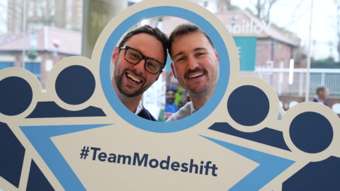 Convention delegates poses with Modeshift STars bopard - Stars shaped people with circle cut out to look through. Text reads; '#TeamModeshift'