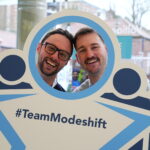 Convention delegates poses with Modeshift STars bopard - Stars shaped people with circle cut out to look through. Text reads; '#TeamModeshift'
