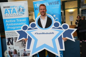 Ed Clancy poses with Modeshift STars bopard - Stars shaped people with circle cut out to look through. Text reads; '#TeamModeshift'