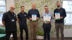 Five men stand in a line holding Modeshift STARS Certificates: James Butterfield - Head of Estates and Site Services at Darlington College Brendan Fish - Director of Biologics & RNA Centre of Excellence (CPI) Andrew Bean – Business Travel Advisor, Darlington Borough Council Tom Murray – Modeshift STARS Programme Manager (Business) 