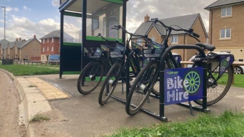 Three bikes parked by a shelter with sign that reads: Bike Hire