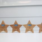 Four star shaped trophies with Modeshift STARS logo stand on white surface.