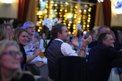 Modeshift 2023 Sustainable Travel Awards - crowd seated at tables, twinkling lights in background, applauding winners