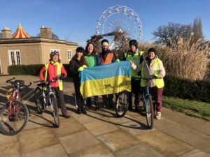 A group of people standing next to each other holding a  Ukrainian flag