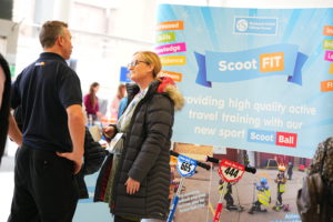 Two people talking, display stands in the background.