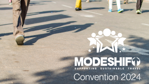 Group of people walking down a road, just their feet/legs in view. Modeshift Convention logo in the bottom right corner. Text reads: Modeshift Convention 2024. Sponsored by SMART Transport Hub.