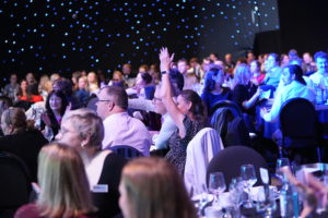 Audience at the National Sustainable Travel Awards, clapping and smiling looking towards the stage.