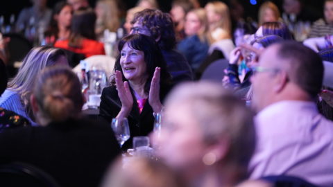 Audience at the National Sustainable Travel Awards, clapping and smiling looking towards the stage.