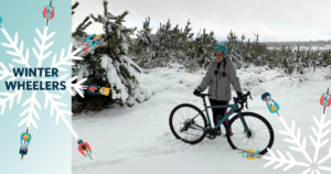 Snowy scene, woman stands by bicycle. Text on left hand side reads: 'Winter Wheelers'.