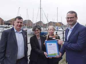 Credit: Business Works. Four people stand together. Two women in the centre hold a Modeshift STARS certificate. 