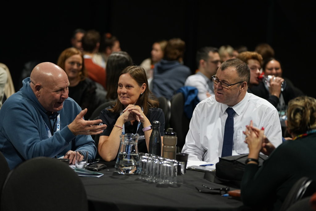 Several people seated at a table, actively discussing and exchanging thoughts in a collaborative atmosphere.