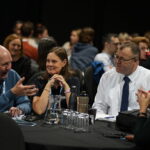 Several people seated at a table, actively discussing and exchanging thoughts in a collaborative atmosphere.