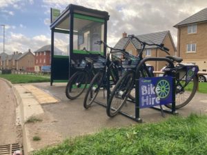 Three bikes parked by a shelter with sign that reads: Bike Hire