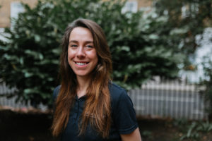 Emily Sykes smiles at camera. Wearing blue t-shirt.