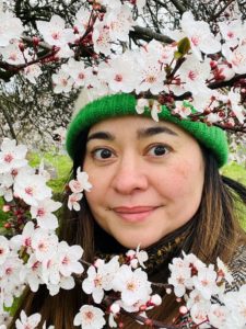 Hana Sutch, CEO & Co-Founder, Go Jauntly stands next to cherry blossom tree