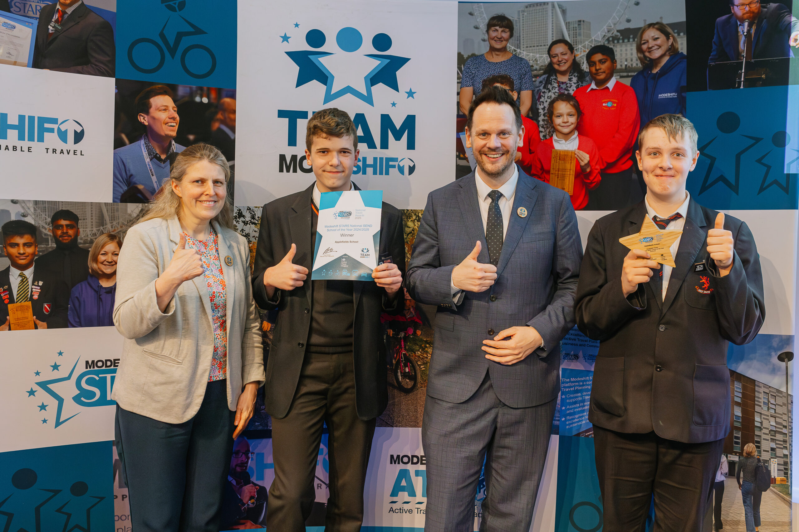 Four people smile, making thumbs up gestures. Two students in school uniform hold up a star shaped award and certificate.