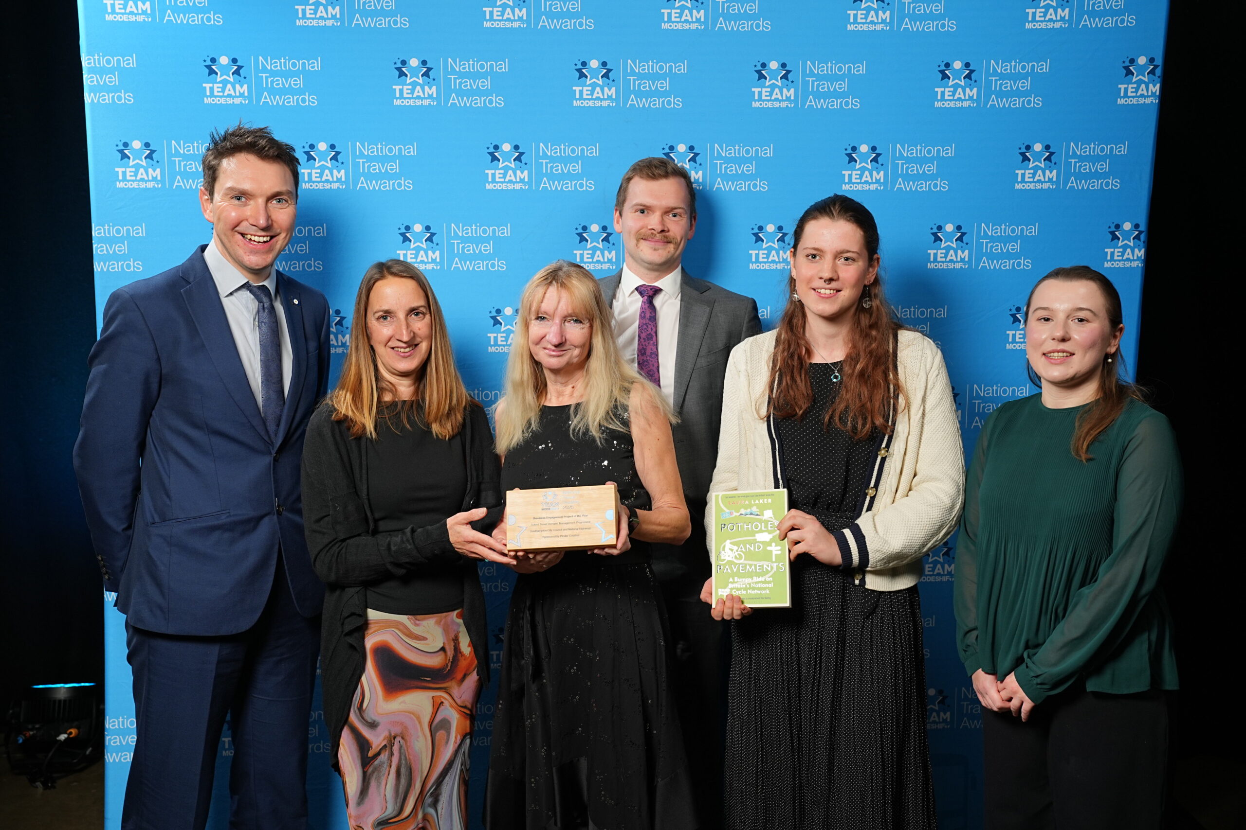 Business Engagement Project of the Year Sponsored by Pindar Creative Solent Travel Demand Management Programme Southampton City Council and National Highways Group of people stand smiling, central figures holding their TeamModeshift Award