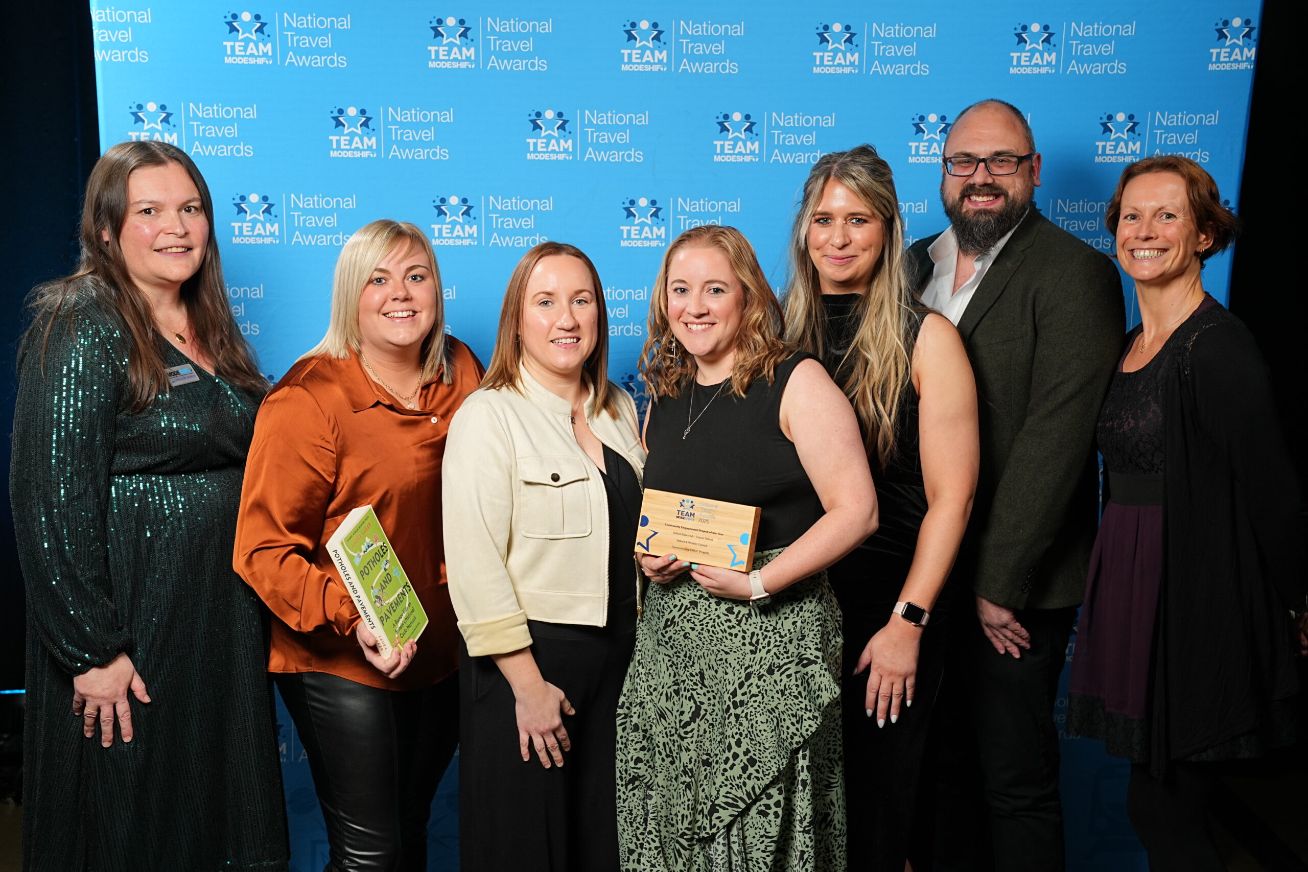 Community Engagement Project of the Year Sponsored by PWLC Projects Telford Bike Hub - Travel Telford Telford & Wrekin Council Group of people stand smiling, central figures holding their TeamModeshift Award