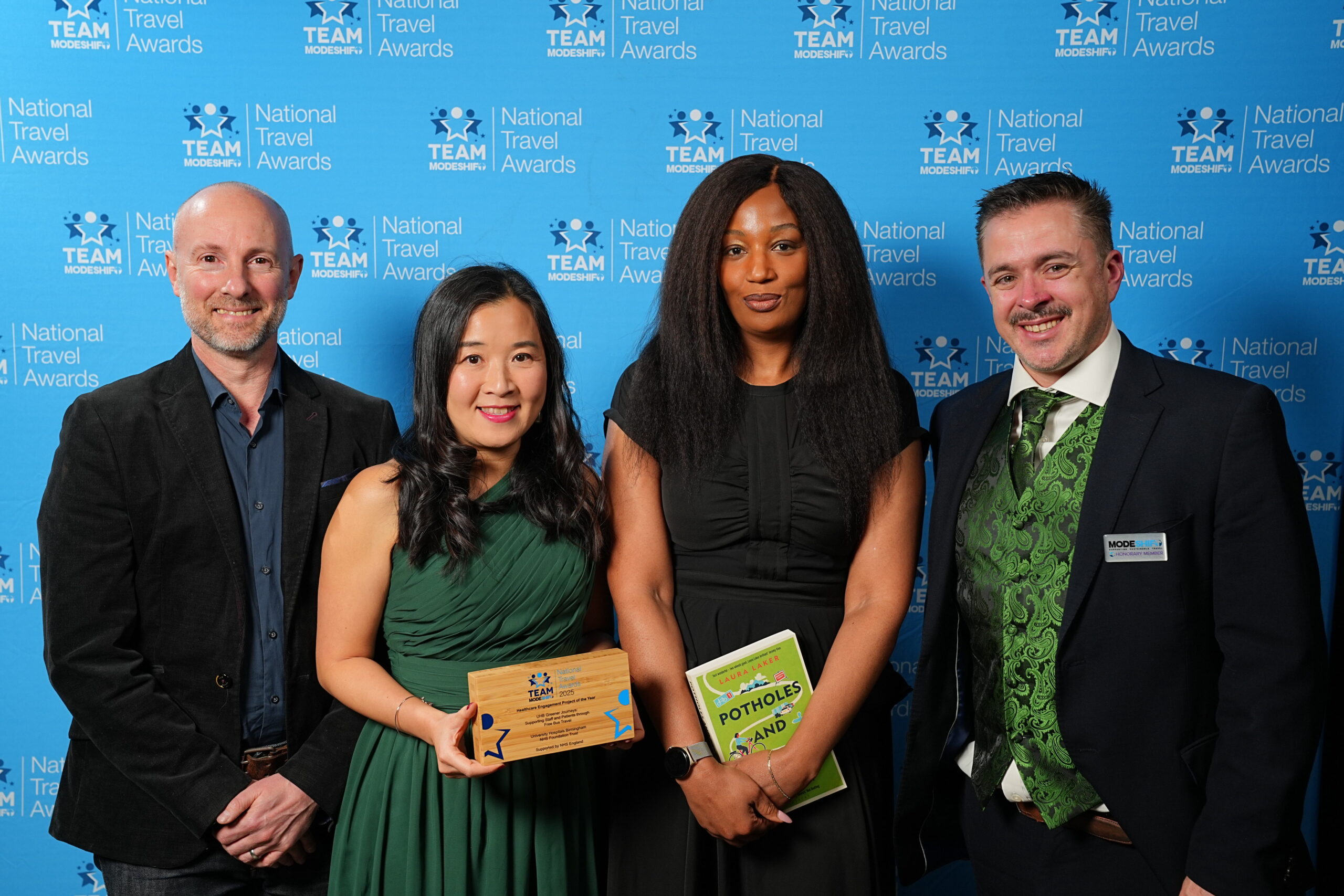 Healthcare Engagement Project of the Year Supported by Active Travel England UHB Greener Journeys: Supporting Staff and Patients through Free Bus Travel University Hospitals Birmingham NHS Foundation Trust Group of people stand smiling, central figures holding their TeamModeshift Award