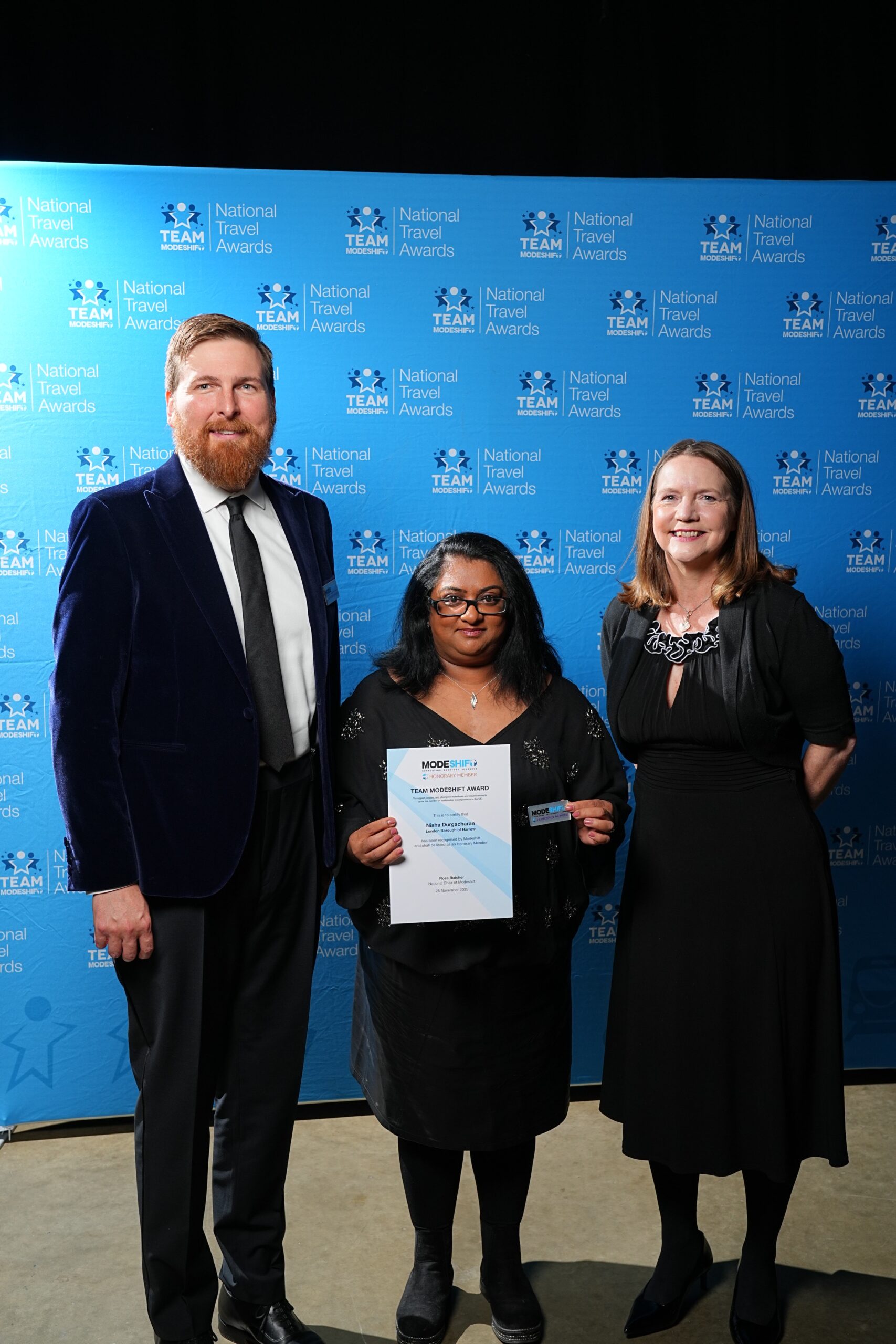 Nisha Durgacharan, Harrow Borough Council poses with Honorary Member Certificate, two people smile at camera either side.