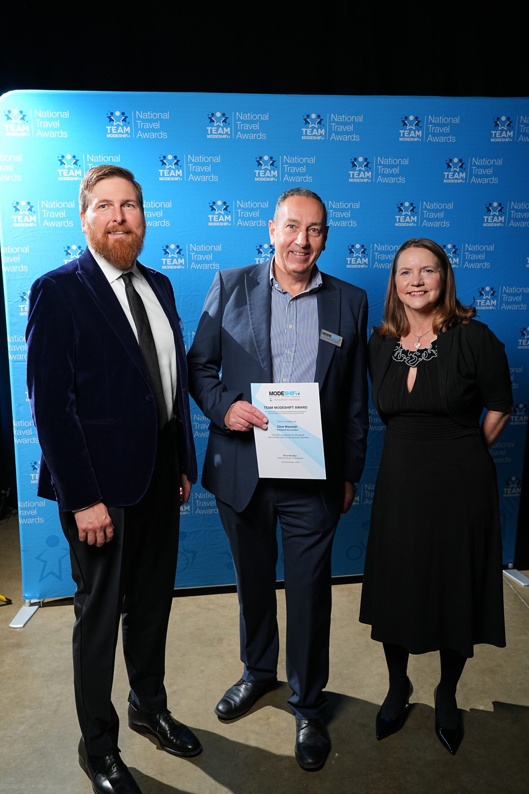 Clive Wanstall, Transport for London poses with Honorary Member Certificate, two people smile at camera either side.