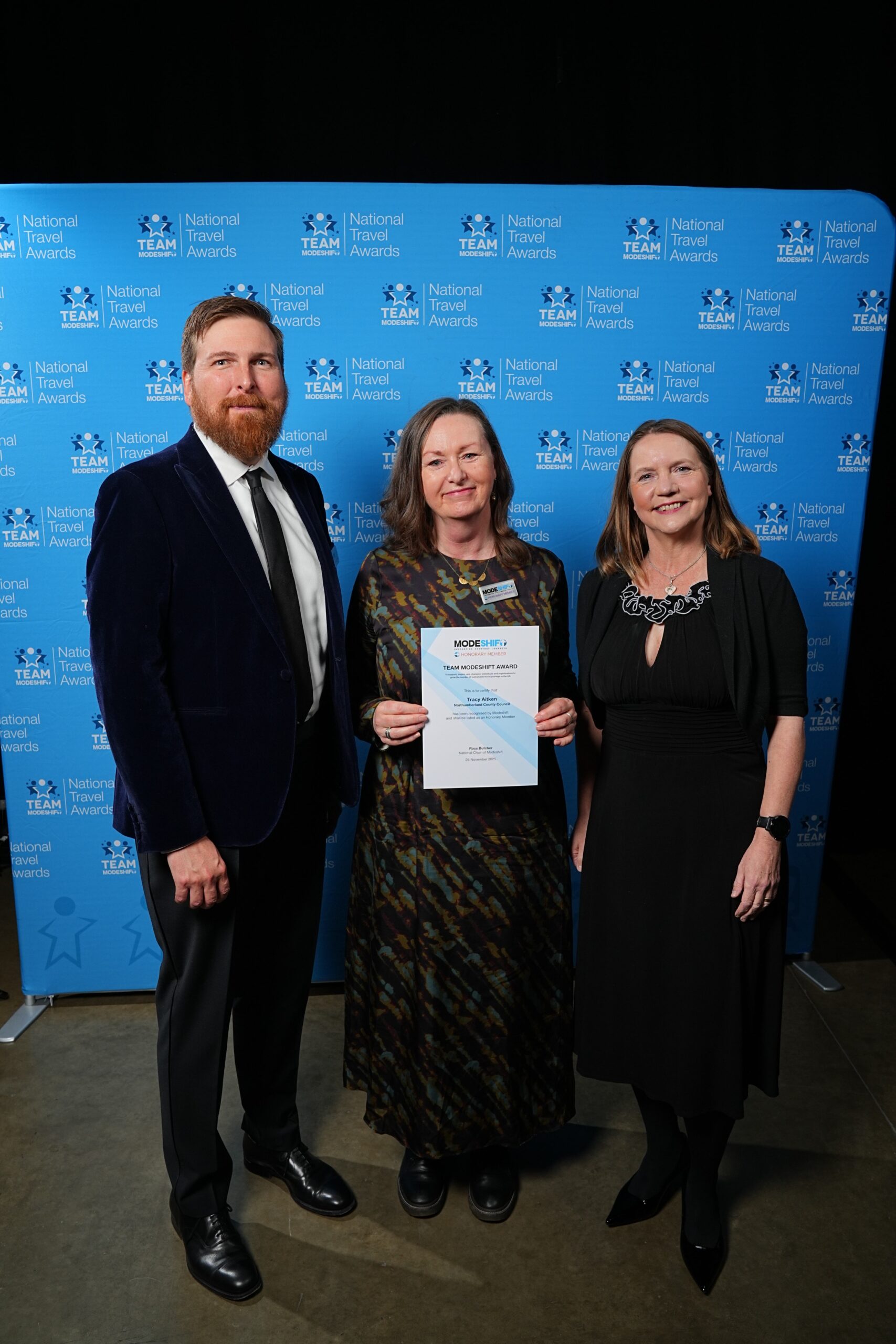 Tracy Aitken, Northumberland County Council poses with Honorary Member Certificate, two people smile at camera either side.