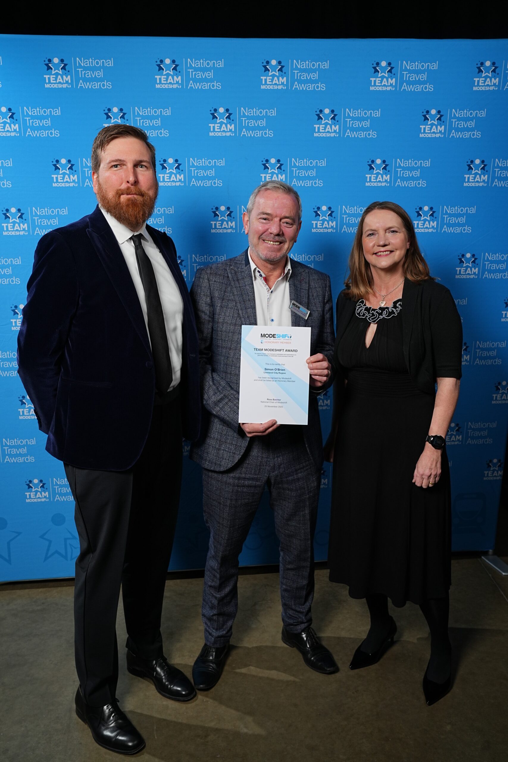 Simon O’Brien, Liverpool City Region poses with Honorary Member Certificate, two people smile at camera either side.