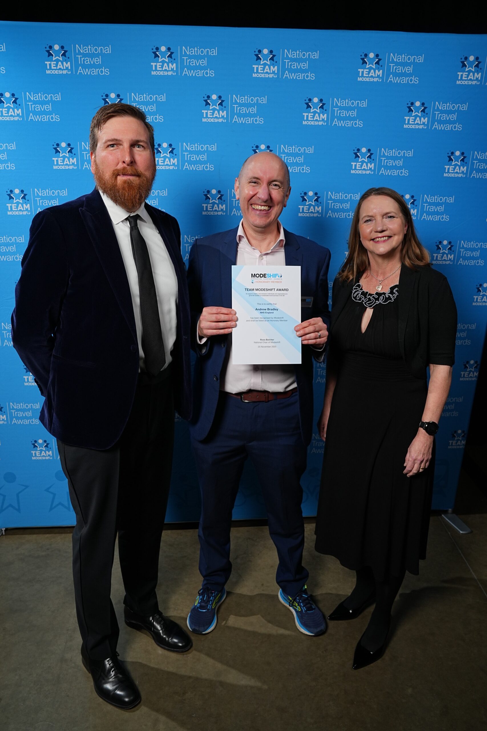 Andrew Bradley, NHS England poses with Honorary Member Certificate, two people smile at camera either side.