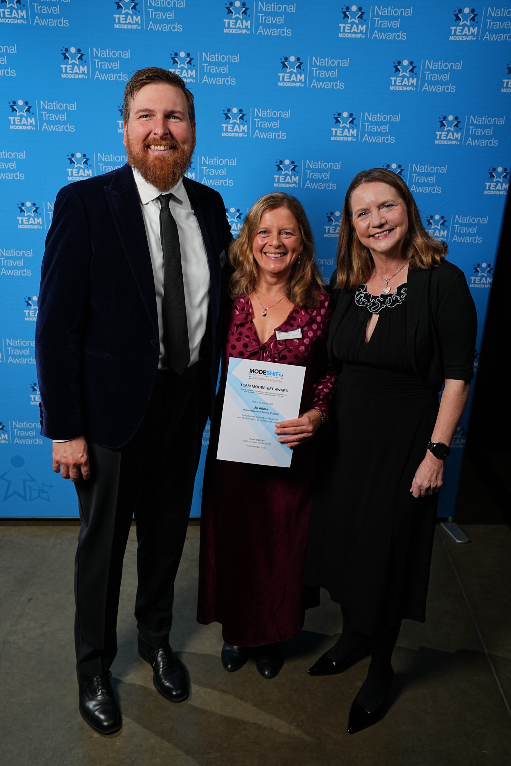 Jo Atkins, Gloucestershire County Council poses with Honorary Member Certificate, two people smile at camera either side.