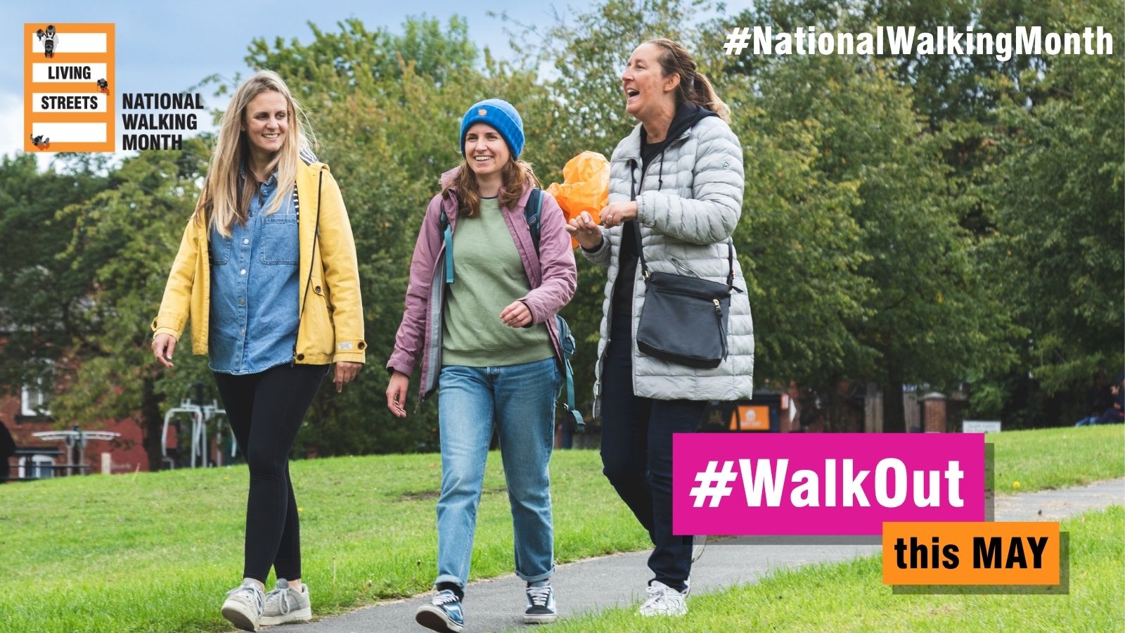 Three women walking together on a park path surrounded by green trees during National Walking Month.