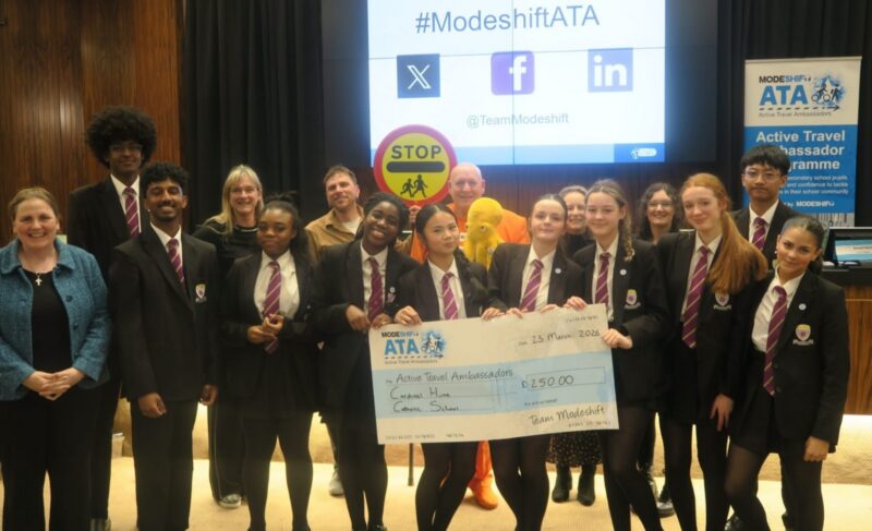 Students in school uniform pose with a large cheque for the Active Travel Ambassadors Campaign funding awarded at the Campaign Junction event.