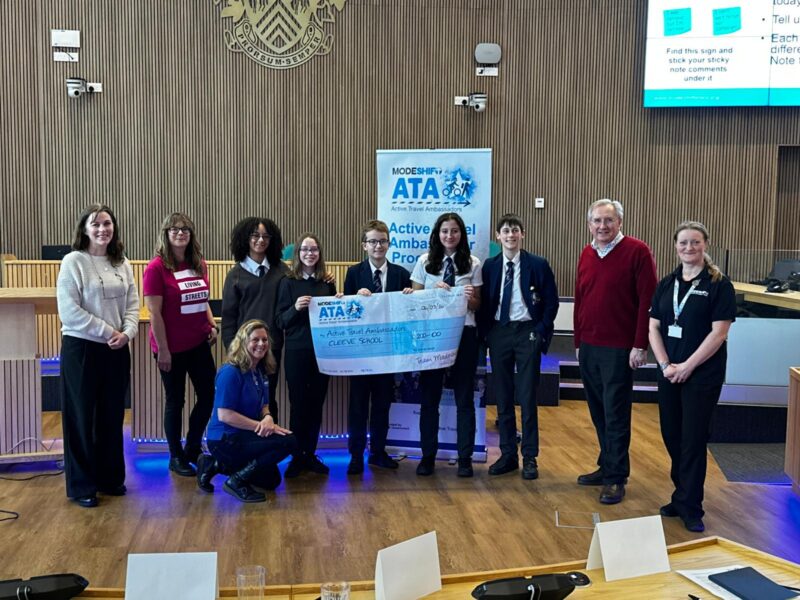 Students in school uniform pose with a large cheque for the Active Travel Ambassadors Campaign funding awarded at the Campaign Junction event.