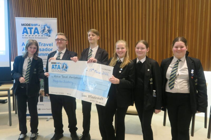 Students in school uniform pose with a large cheque for the Active Travel Ambassadors Campaign funding awarded at the Campaign Junction event.