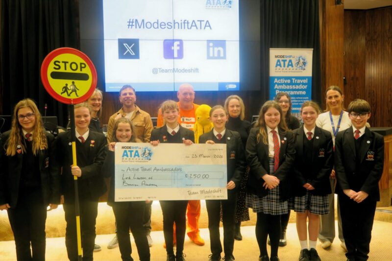 Students in school uniform pose with a large cheque for the Active Travel Ambassadors Campaign funding awarded at the Campaign Junction event.