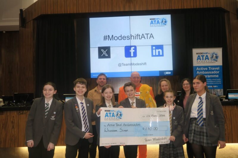 Students in school uniform pose with a large cheque for the Active Travel Ambassadors Campaign funding awarded at the Campaign Junction event.