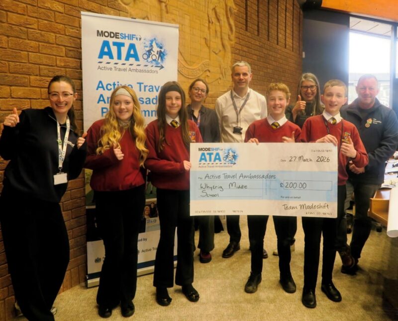 Students in school uniform pose with a large cheque for the Active Travel Ambassadors Campaign funding awarded at the Campaign Junction event.